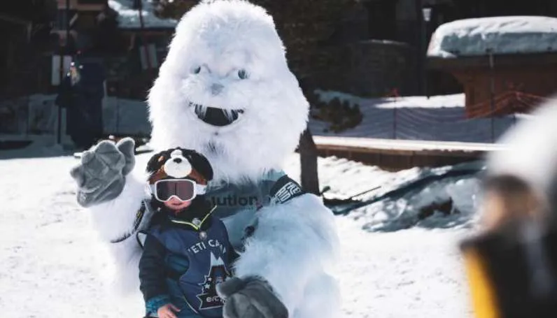 Enfant avec la mascotte Yéti au Yéti Camp aux Arcs pendant une animation neige